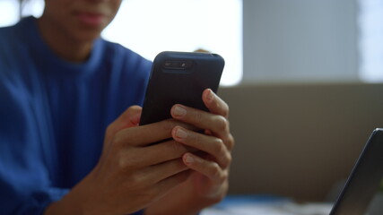 Businesswoman typing message on mobile phone. African woman using cellphone 