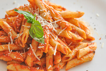 Spicy creamy penne pasta served with basil garnish