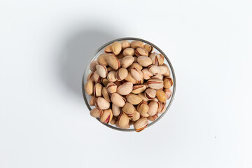 Pistachios in a glass cup on a white background. Close-up.