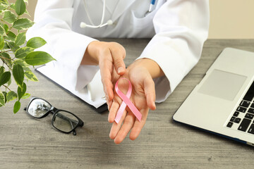 Female doctor holds breast cancer awareness ribbon