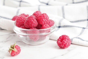 composition of ripe raspberries in a bowl on a textured background