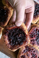 Hand holds a delicious, appetizing homemade pie with berry filling, cooked in a Russian oven. Hearty, hot snack. Traditional cuisine. 