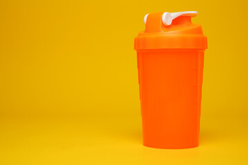 fitness protein shaker. isolated plastic shaker for whey powder in the gym. bodybuilding equipment background. supplement drink drink mix
