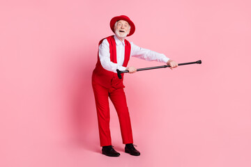 Full body photo of aged cheerful man happy positive smile dancer music event stick isolated over pink color background