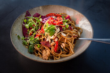 Udon stir-fry noodles with chicken in bowl