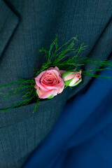 Bridal bouquet in groom's suit. Pink roses