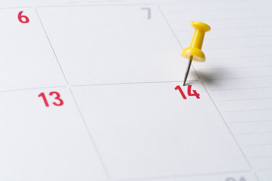 close up of pin on calendar on the table background, planning for business meeting or travel planning concept