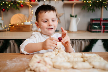 a little boy himself cooks dumplings with cherries in the New Year's kitchen. 