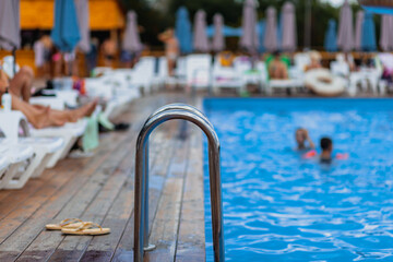 Ladder stainless handrails for descent into swimming pool. Swimming pool with handrail . Ladder of...