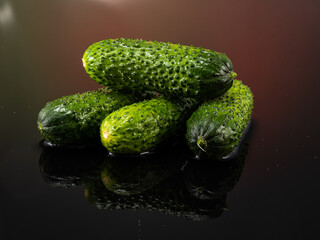 pimpled cucumbers on a dark background with splashes of water