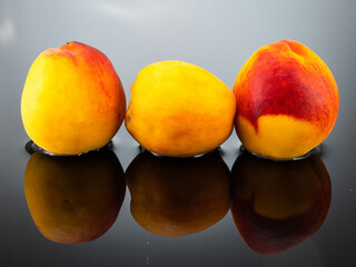 ripe peaches with water splash on gray background