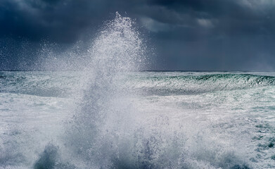 Wave curling over and breaking during cyclone Ola with stormy sky