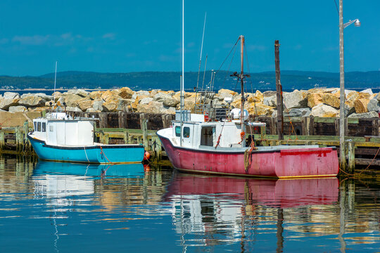 A pair of fishing boats docked at the wharf in the Atlantic Ocean in rural Nova Scotia
