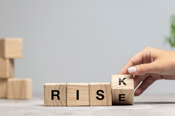 Wooden cubes, blocks with word RISK in female hand. Conceptual image about human rights, education, social issues, mental health, education and personal development.