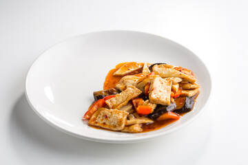 Asian spicy stir fry vegetable with tofu and shiitake isolated on white background