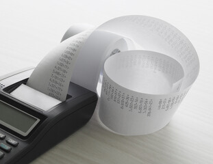 Calculator sitting on desk with printed tape full of numbers