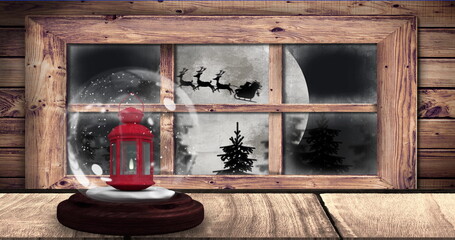 Image of snow globe with lantern and silhouette of santa claus in sleigh