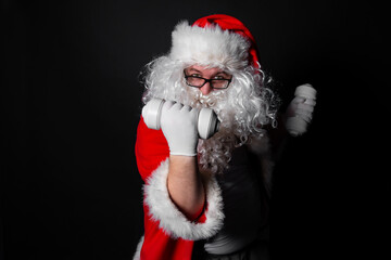 Fat Santa Claus with dumbbells in his hands. Athletic man. Christmas and traditions. Black background.