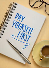 Pay yourself first - financial advice, handwriting in a spiral notebook with coffee, personal finance concept