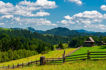 Fototapeta na wymiar composite summer landscape, fence along the hillside meadows of the mountains. High quality photo