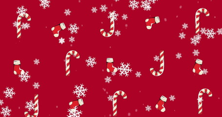 Image of candy canes and christmas stockings with snow falling on red background