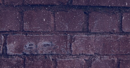 Image of winter scenery snow falling against brick wall