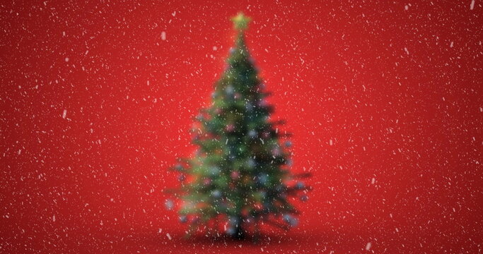 Image of christmas tree with snow falling on red background