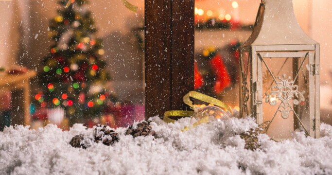 Image of christmas tree seen through window with snow falling