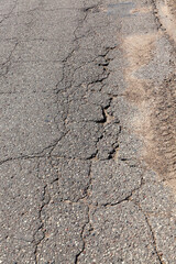 an asphalt road with a lot of holes and damage