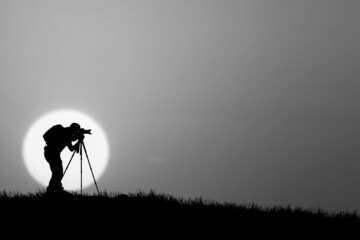 Obraz na płótnie Canvas silhouette of a photographer in a field