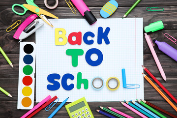 Different school supplies with text Back to School on wooden background