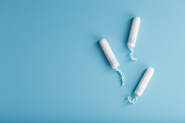 Cotton tampons on a blue background with a free space.