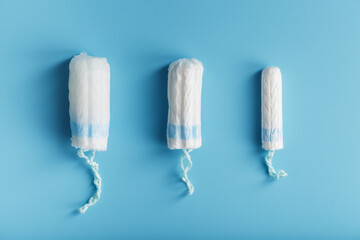 Cotton tampons on a blue background with a free space.