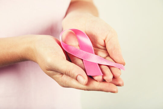 Breast cancer concept. Female hands with pink ribbon