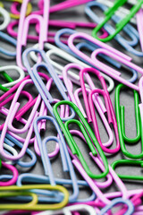 Multicolored paper clips scattered as textured background