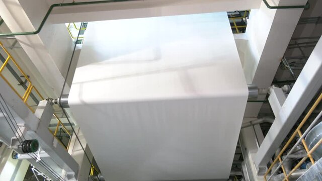 Paper rolls in a printing press of a large printing house. machines for the production of paper rolls for further processing in a printing plant - recycling of waste paper. Paper production machine
