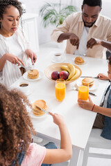 Obraz na płótnie Canvas african american family eating pancakes for breakfast