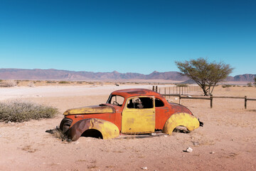 Abandoned derelict old car in the sandy desert