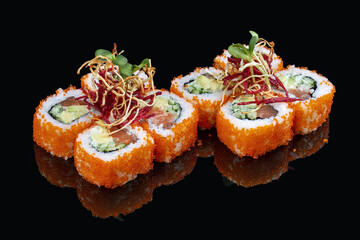 California roll with salmon and tobiko caviar on glossy black background