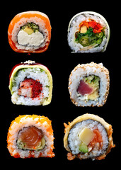 A variety of maki sushi on a glossy black background