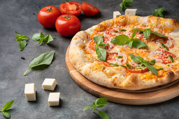 Pizza Margherita on gray stone background, Pizza Margarita with Tomatoes, Basil and Mozzarella Cheese close up.