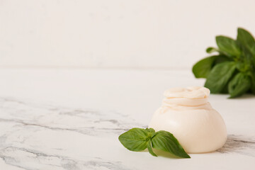 Delicious fresh cheese made from cream and milk - burrata. Italian tender cheese with herbs on a light background