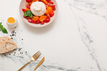 Delicious fresh cheese made from cream and milk - burrata. Italian delicate cheese with olive oil. Bread and salad of tomatoes and herbs, cherry tomatoes on a twig.