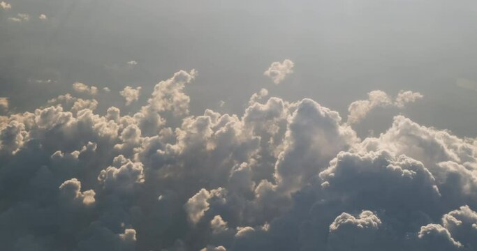 Dreamy clouds cumulus backlit by sun light, top view perspective. Meteorology forecasting cloudy weather. Meditative flying trip over fairy cloudscape. Beautiful sky haze. 4k aerial footage in heaven