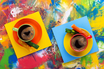 Cup of coffee and candied fruit at colorful abstract background texture. Coffee break