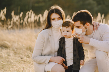 Stylish family in a masks walking on a spring field