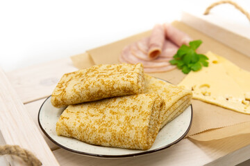 Russian pancakes with ham and cheese close-up.