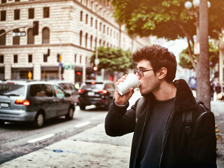 Attractive young man in modern city center drinking coffee