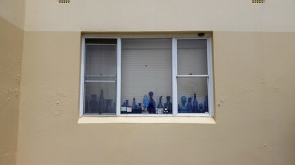 Fototapeta na wymiar Window in a building with blue glass bottles