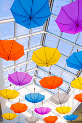 Fototapeta na wymiar Bright colorful umbrellas hanging from the ceiling